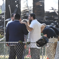 Rabbi Yitzchok Lerman, who survived with his family in the fire that completely destroyed Congregation Beth El synagogue, stands in front of the synagogue's ruins in Rutherford, New Jersey on August 8. (Kyle Mazza/Anadolu via Getty Images via JTA)